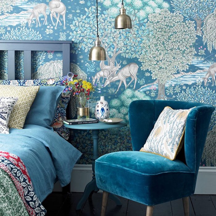 modele de tapisserie chambre bleue avec motif foret avec arbres et animaux, lit gris, linge de lit bleu et à imprimé floral, fauteuil bleu canard