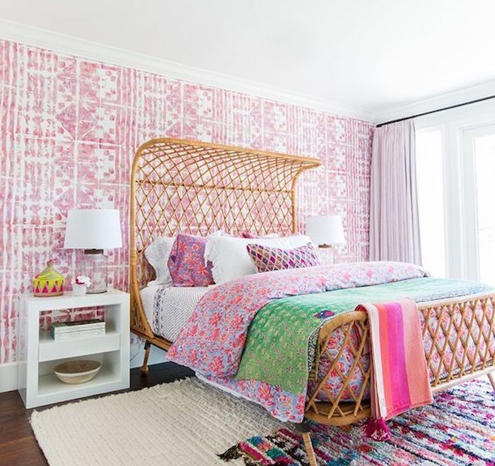 décoration chambre adulte avec papier peint oriental rose et blanc, lit exotique, linge de lit et tapis coloré, table de nuit blanche