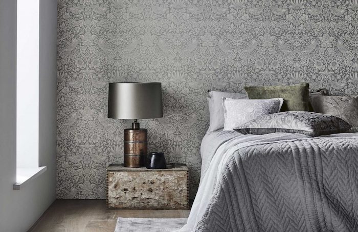 papier peint tendance gris et blanc, linge de lit gris, coussins gris et vert, parquet bois brut, table de nuit façon usé