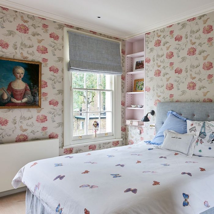 papier peint vintage, roses rouges sur un fond blanc, linge de lit blanc avec imprimé papillon, tête de lit capitonnée, peinture cadre baroque