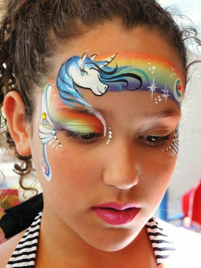 peinture visage, arc-en-ciel et licorne sur le visage d'une jeune fille