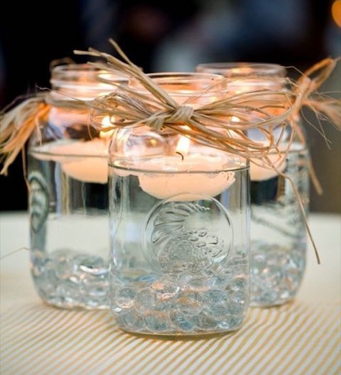 deco mariage champetre chic simple, pot en verre transformé en bougeoir avec de l huile dedans et bougies flottante