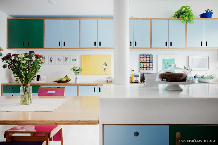 repeindre meuble cuisine, placards repeints en vert et bleu pastel, ilot central et table en bois, plan de travail bois et crédence décorée de dessins