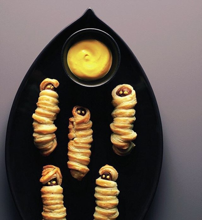 idée originale pour un aperitif halloween original, des saucissons feuilletés façon momies garnies de moutarde
