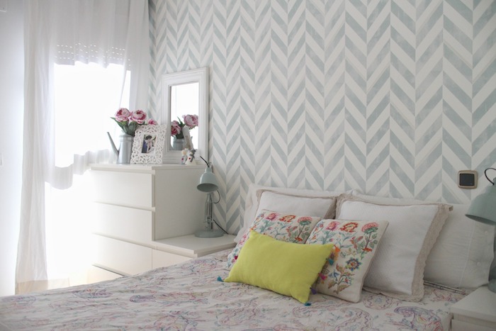 tapisserie murale gris et blanc, linge de lit et coussins coloré, commode blanche, bouquet de fleurs, deco chambre adulte