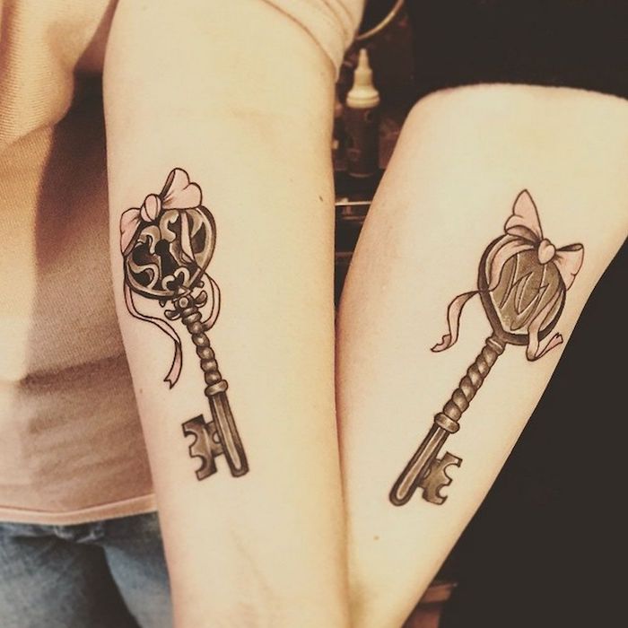 tatouage commun meilleure amie, art corporel en encre sur les bras à design clé avec ruban rose