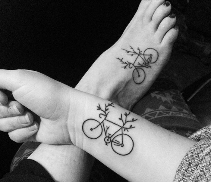 petit tatouage, dessin en encre sur le poignée et le pied à design vélo avec branchettes, photo amitié blanc et noir