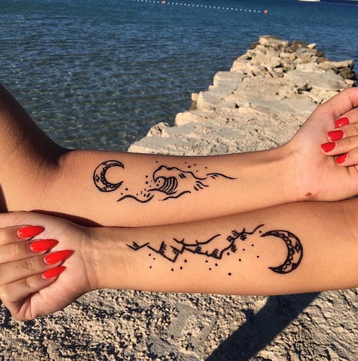 tatouage commun meilleure amie, art corporel en encre à design vague mer soleil, mains féminins aux ongles longs et courts à vernis rouge