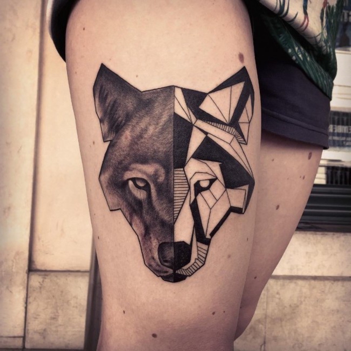 un tatouage graphique et géométrique de loup à deux faces sur la cuisse