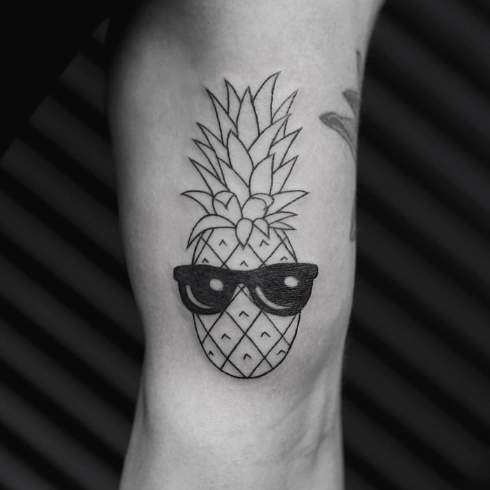 un tatouage simple mais impressionnant représentant un ananas portant des lunettes