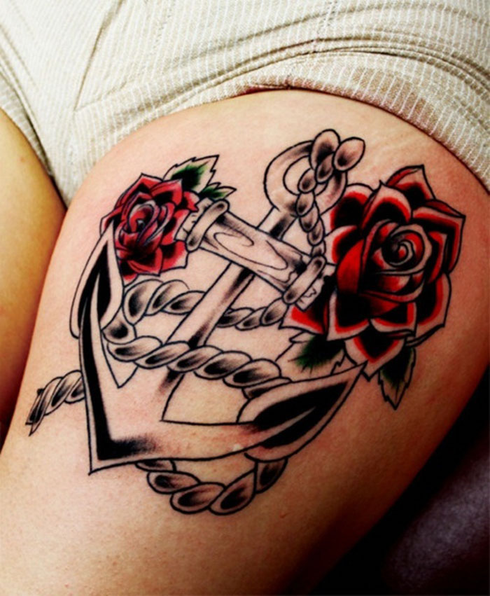 tatouage ancre marine sur la cuisse de femme avec roses rouges