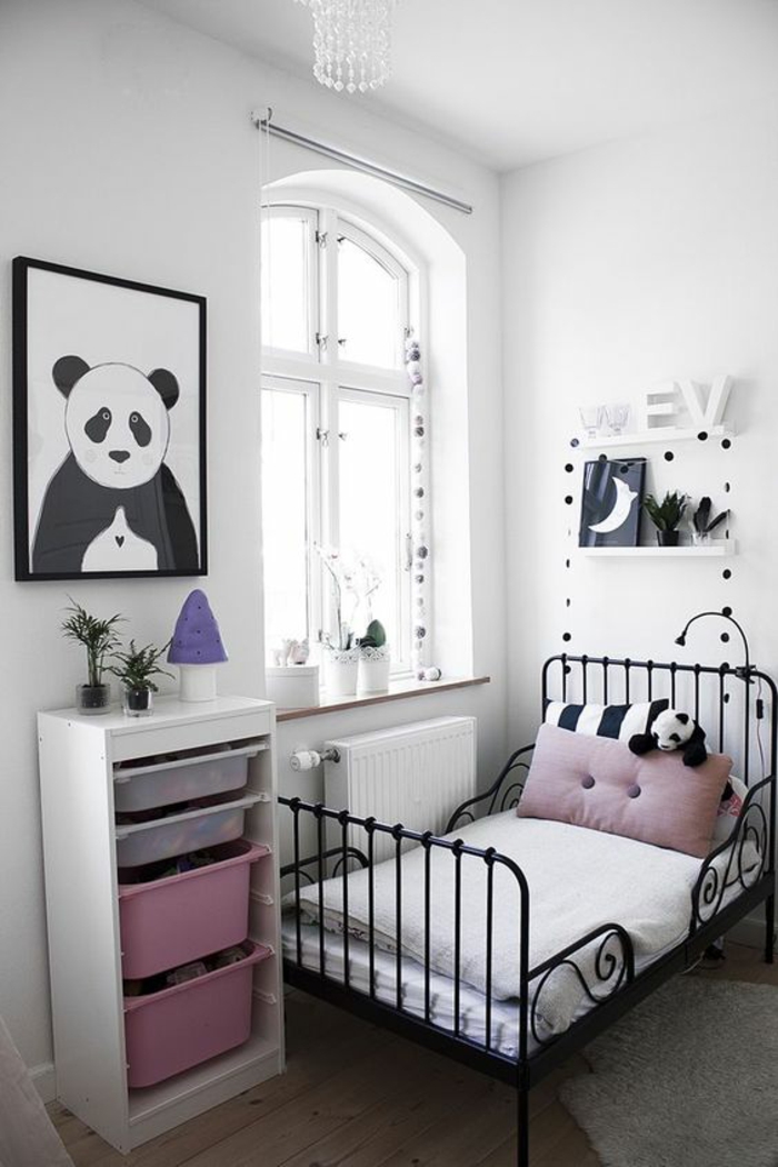 chambre de 9m2 avec lit vintage en métal noir, des étagères blanches, une panda en peluche sur le lit et sur un grand tableau accroché au mur, chambre réalisée en rose et blanc