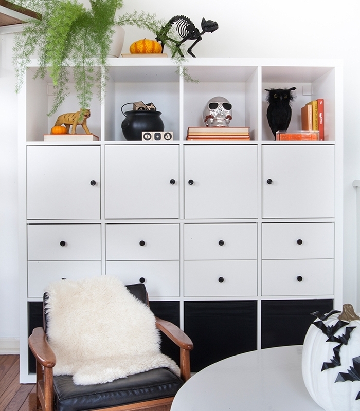 deco halloween maison blanc et noir, pièce aux murs blancs avec sol en bois et meubles en bois, citrouille blanche avec chauves-souris en papier noir