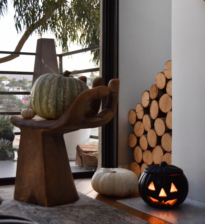 modele citrouille halloween, déco intérieur avec citrouille peinte noir lumineuse et chaise en bois moderne forme main