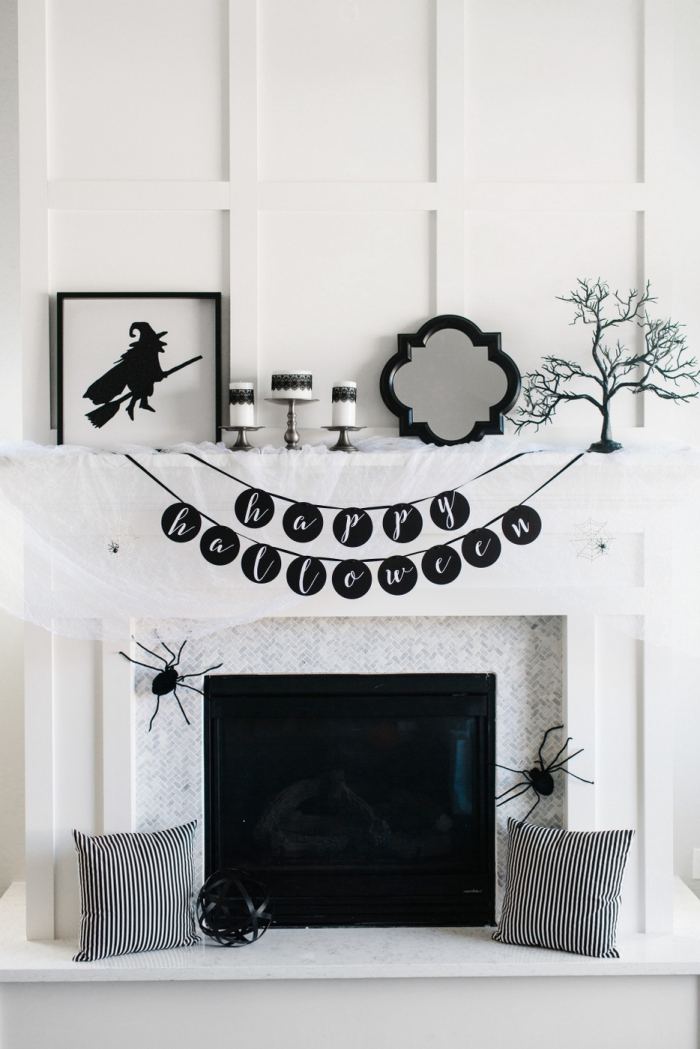 decoration d interieur, salon aux murs blancs avec cheminée en marbre et porte noire, coussins décoratifs rayés en blanc et gris foncé