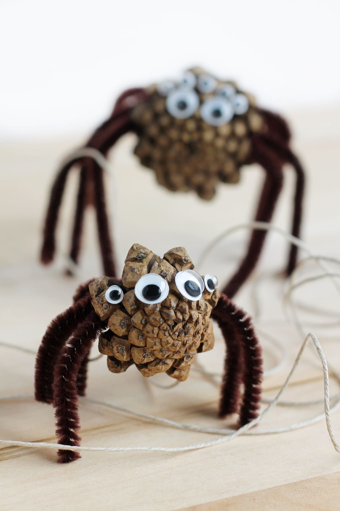 idée bricolage avec des pommes de pins nature transformées en araignées d halloween 