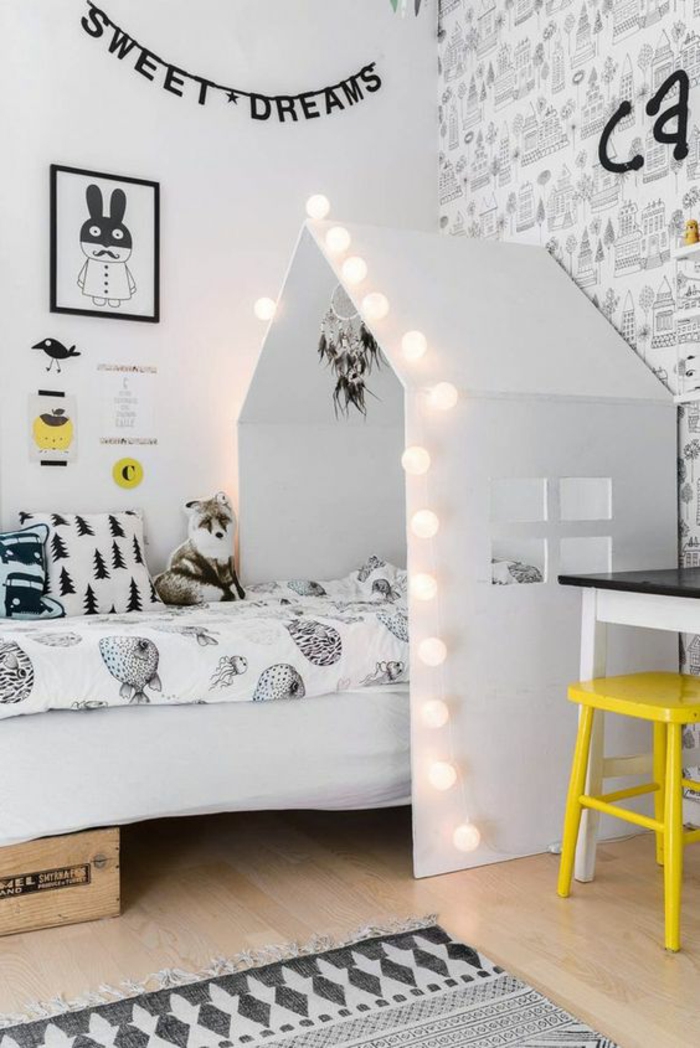 aménager une petite chambre enfant avec tête de dans une maisonnette blanche avec des ampoules lumineuses, murs décorés avec des inscriptions amusantes en couleur noire 