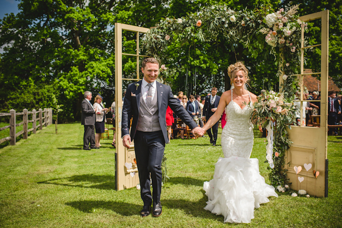 arche fleurie de mariage, champetre, portes en bois vintage avec décoration de guirlandes fleuries, couple mairée