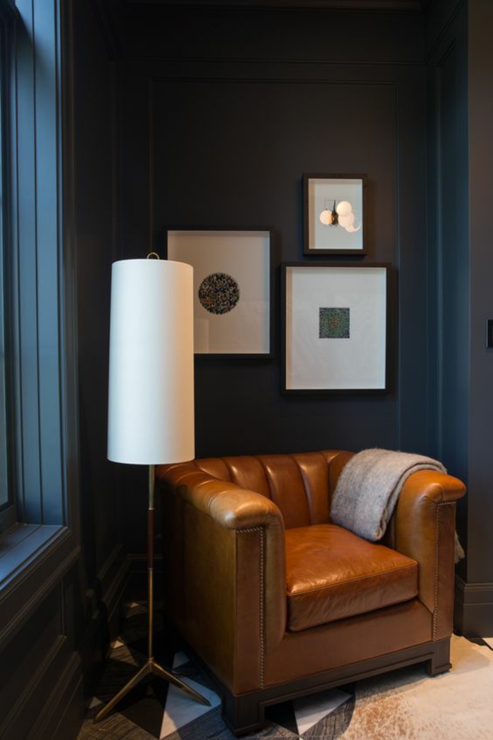 nuance de bleu pour un coin de repos avec grand fauteuil en couleur caramel large et profond pièce avec un plafond haut