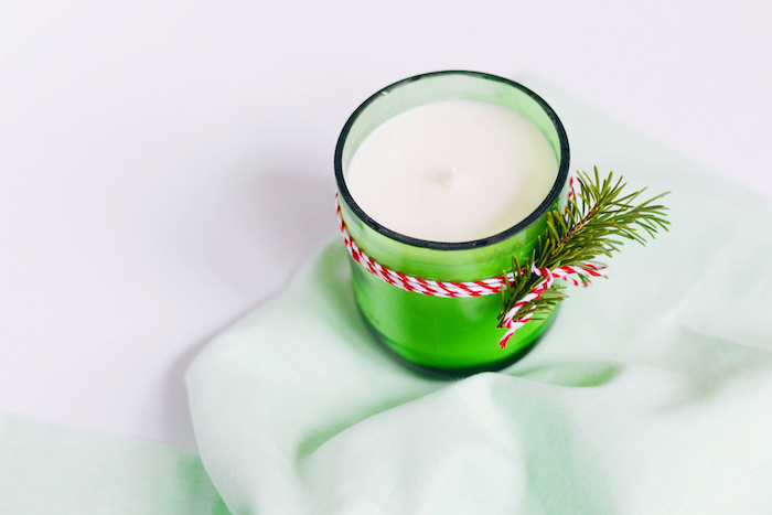 comment faire des bougies, exemple bougie dans un pot en verre vert, decoration de branche de pin et fil blanc et rouge, activite noel