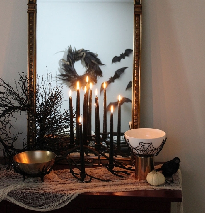accessoire halloween, meuble en bois avec miroir vintage décorés en tissu blanc et bougeoirs noirs