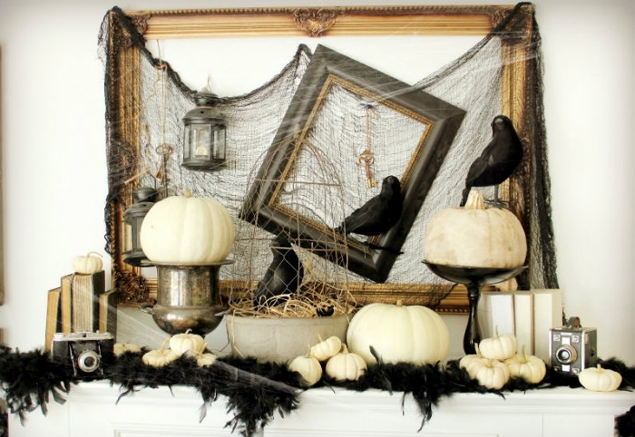 deco halloween, intérieur aux murs blancs et cadres noires avec toile d'araignée pour Halloween et petites citrouilles blanches