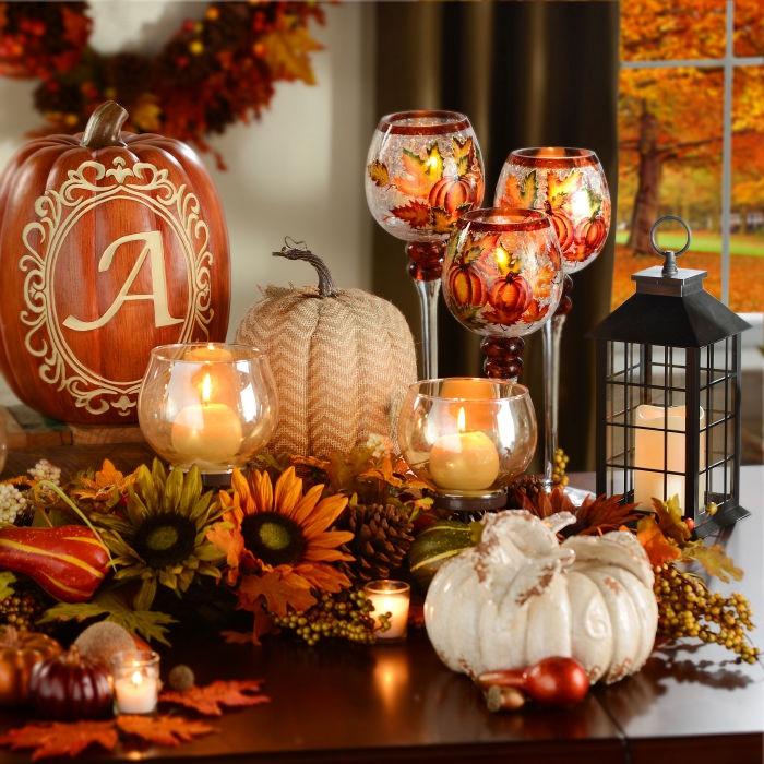 activité manuelle halloween, bougies blanches dans récipients ovales en verre, feuilles et fleurs séchées orange et vert