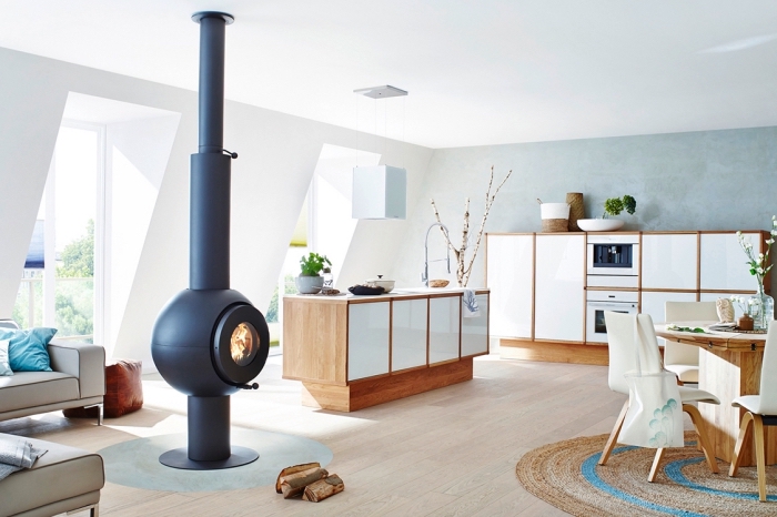 inspiration scandinave, meubles de cuisine blancs en bois, revêtement de sol en bois stratifié, cheminée noire ronde moderne