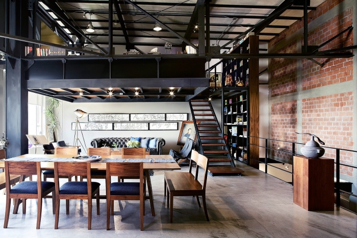 loft industriel, salle à manger ouverte vers le salon avec table à manger et chaises en bois foncé et siège bleu foncé