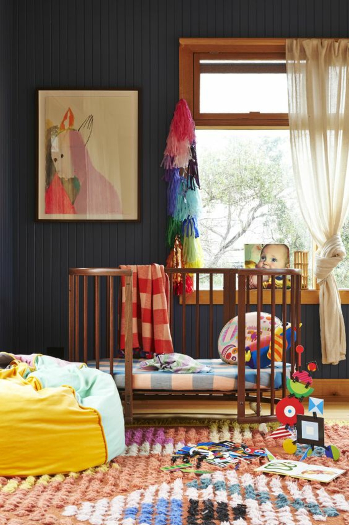 chambre bébé bleu canard avec grand tableau aux couleurs rouge et violette au mur et une grande fenetre