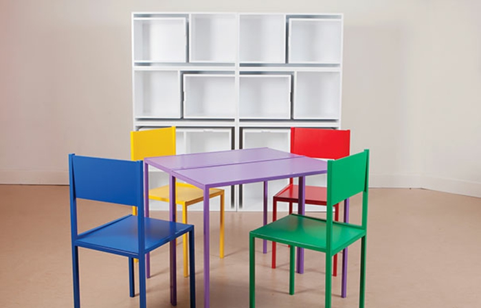 décoration chambre adulte avec quatre chaises et une table qui s'insèrent en un meuble, style ludique, chaises en jaune, vert, bleu et rouge, parquet beige artificiel