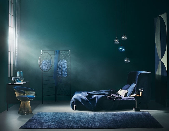 idée de chambre a coucher en bleu petrole et bleu marine, rangement grillage noir, lit et tapis bleu marine, sol gris, fauteuil design, deçor dramatique