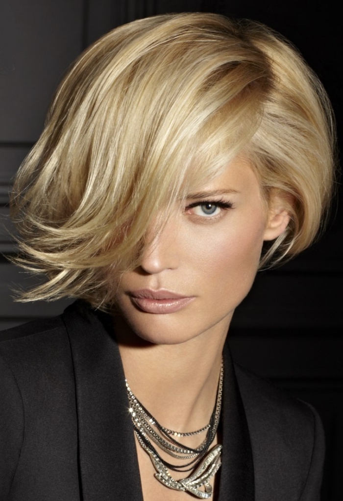 couper sa frange, coiffure féminine aux cheveux courts avec frange longue de côté, couleur de cheveux blond aux reflets miel