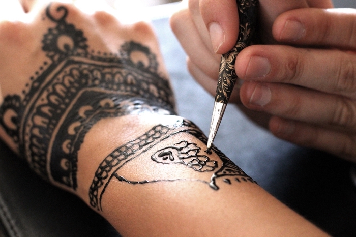 tatouage henné noir, technique de dessiner sur la peau au henné noir, tatouage sur mains pour femme