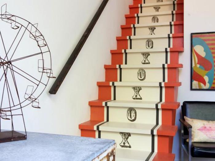 idée comment repeindre un escalier à motif intéressant, rayures rouges, jaunes et noires, stampe en lettres, main courante en bois