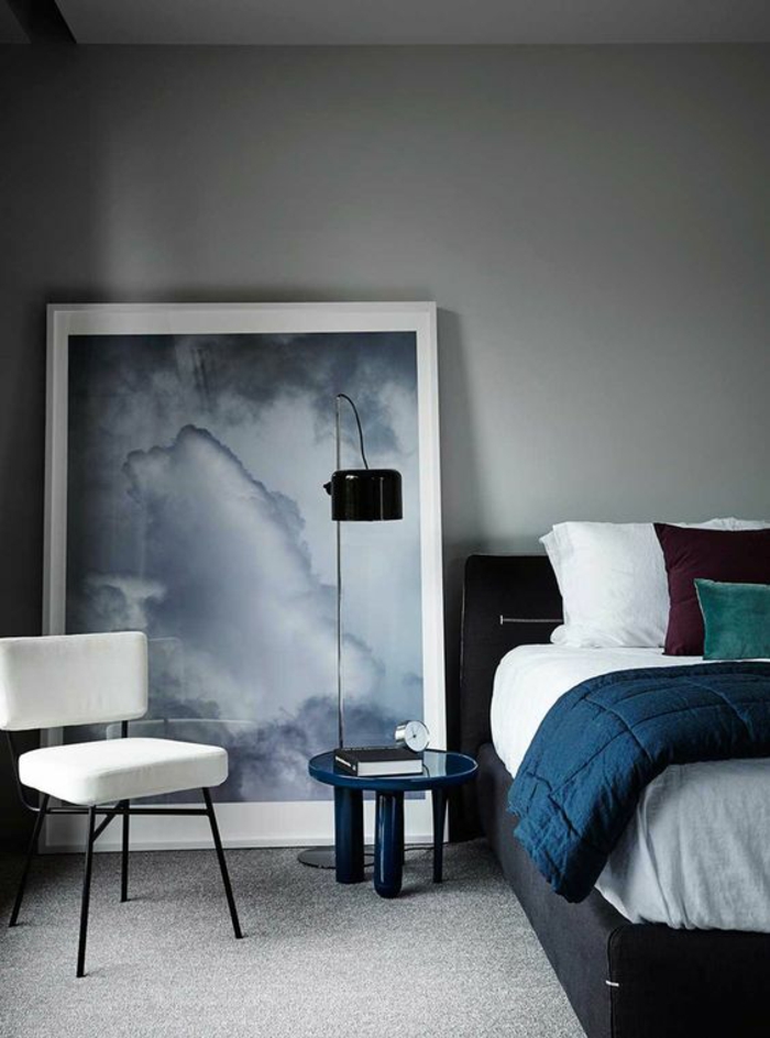 deco chambre adulte bleu avec mur en gris clair et grand tableau avec des nuances grises au cadre en blanc 