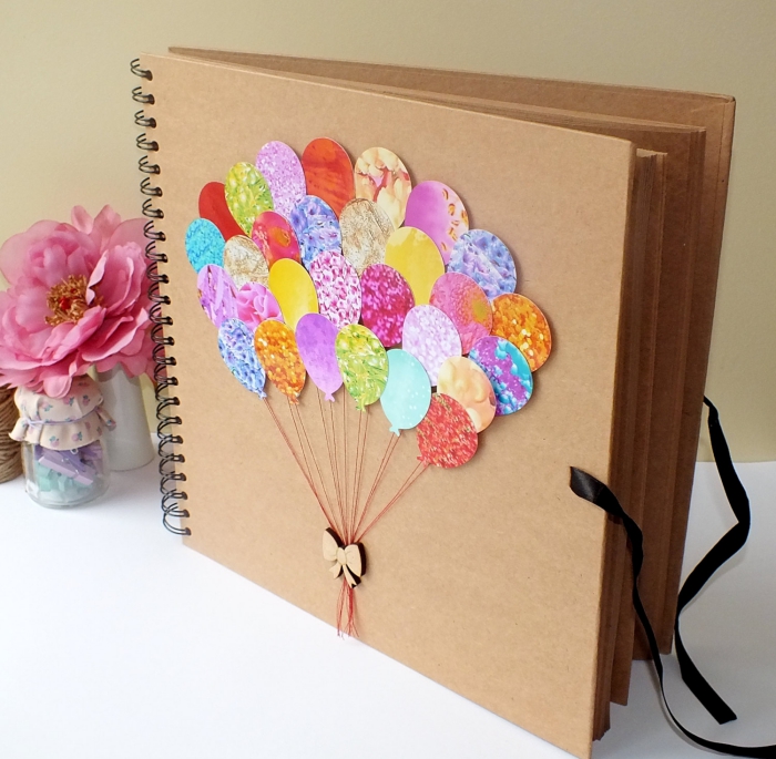 album photo scrapbooking, couverture en papier recyclé avec décoration multicolore à motifs ballons volants et ruban beige