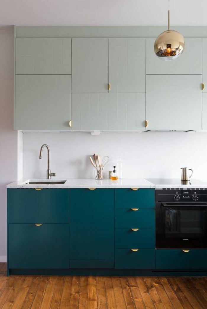 meuble bleu canard, cuisine bleu, luminaire en forme de boule en métal couleur bronze, meuble en couleur menthe verte au-dessus du meuble en bleu canard