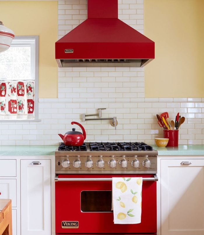 campagne chic decoration de cuisine vintage avec mur couleur jaune, carrelage blanc acnien, aspirateur et fourneau rouge, facade meuble blanc