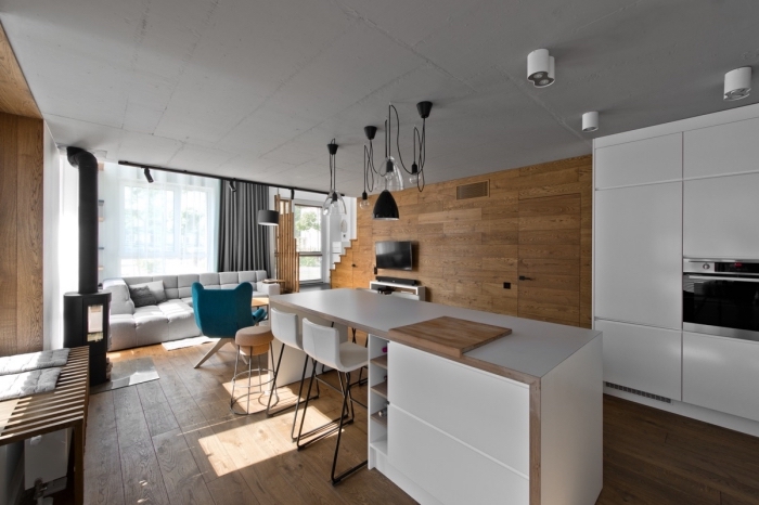 rideau scandinave long en gris anthracite, cheminée moderne noire dans la cuisine, meubles de cuisine blancs sans poignées