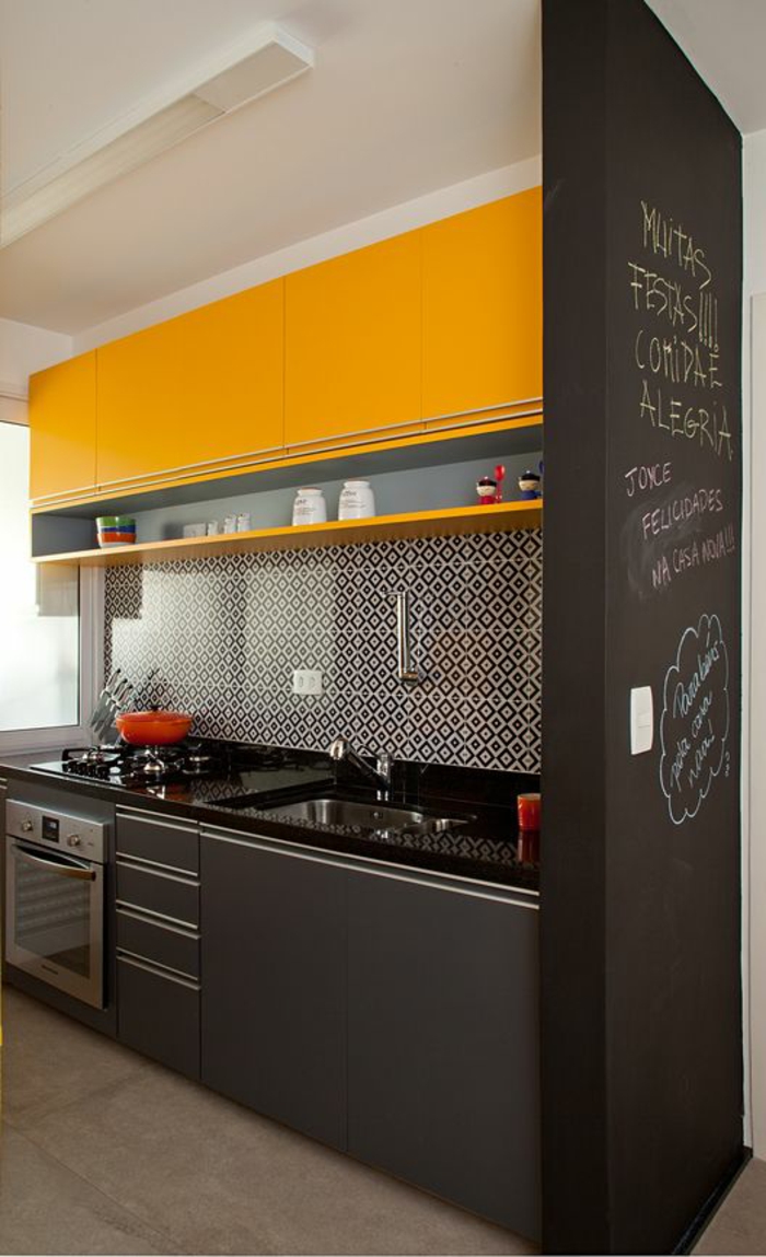 repeindre sa cuisine en gris anthracite et jaune avec un mur tableau noir, plan de travail du lavabo en noir brillant, sol beige