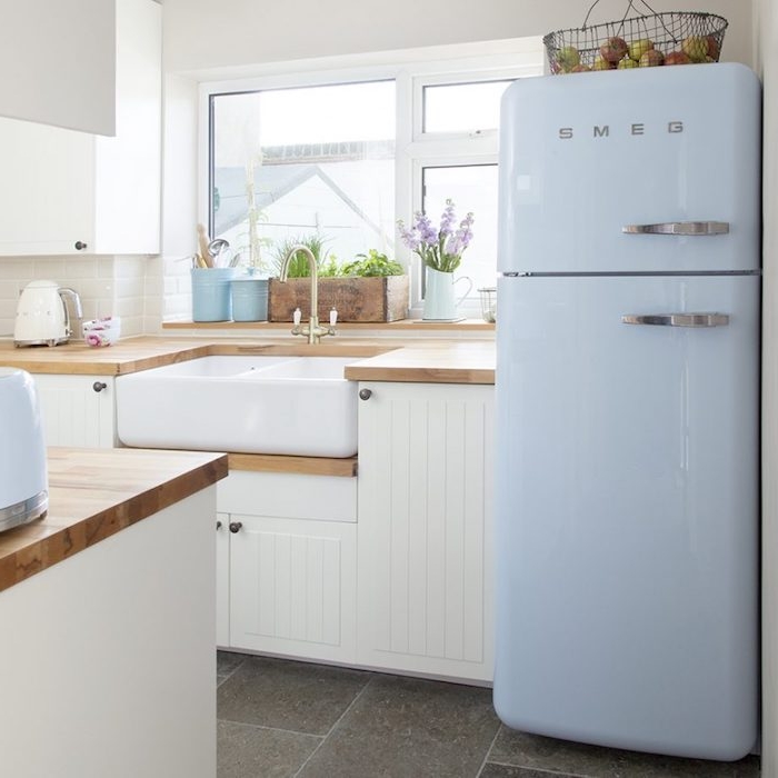 campagne decoration cuisine avec carrelage effet béton, meuble cuisine blanc, frigo bleu clair, plan de travail bois et carrelage blanc