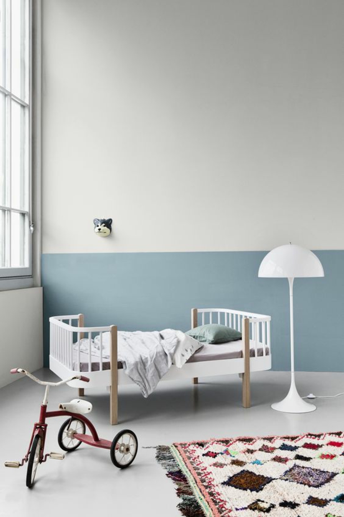 deco chambre bebe garcon bicolore en bleu et blanc aménagement de style minimaliste avec tapis en style ethno aux losanges colorés 