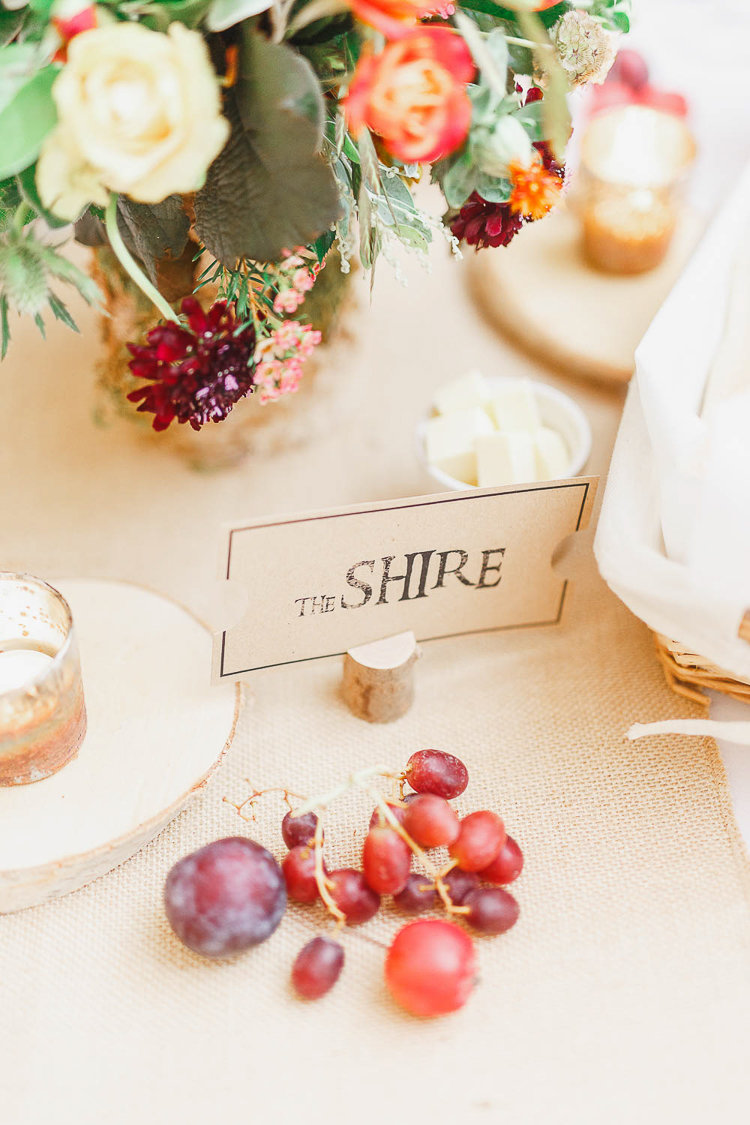 deco table mariage, nappe en toile de jute, nom invité inséré dans une branche en bois, decoration florale et fruits, bougeoirs diy mariage
