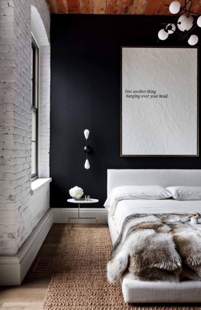 lampe industrielle, chambre à coucher aux murs en briques blanches et peinture noire avec plafond en bois