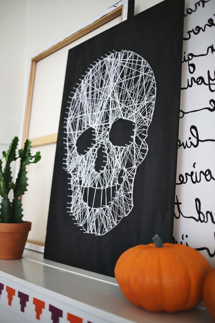 objets décoratif pour Halloween, peinture noire avec crâne en fils blancs, cadre photo bois peint en blanc et noir