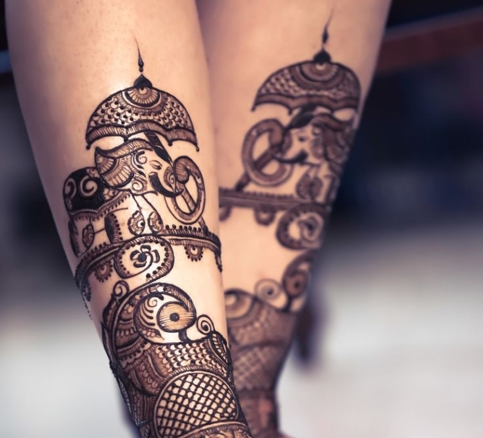 tatouage temporaire, dessin au henné noir sur jambes féminins, tattoo à design ethnique avec petit éléphant et parasol