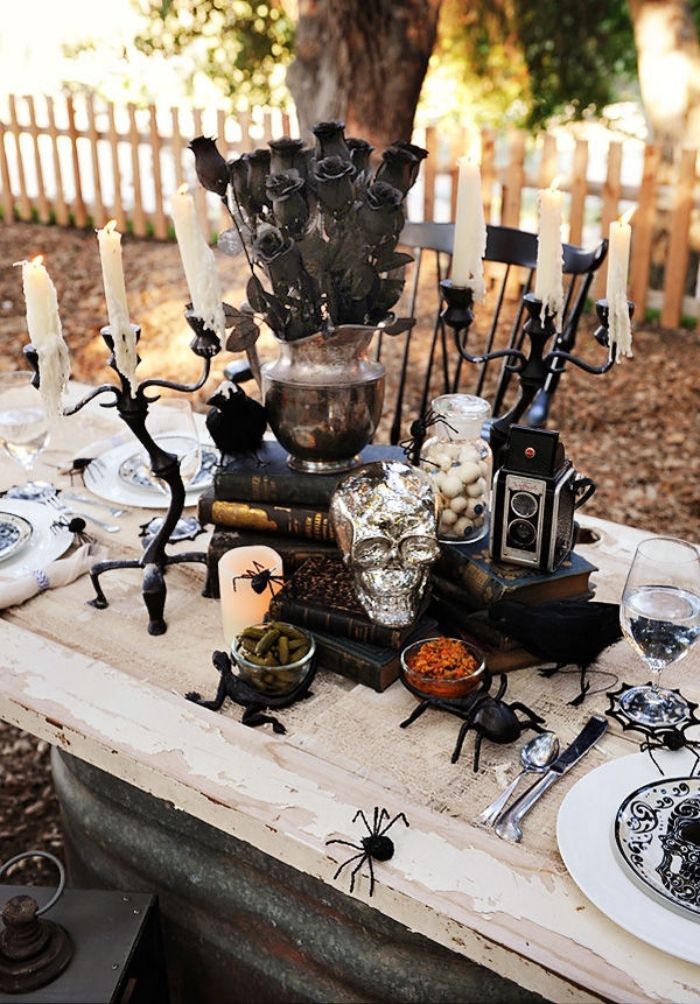 organisation fête Halloween en plein air, table Halloween en blanc et noir avec bougeoirs et crâne en argent
