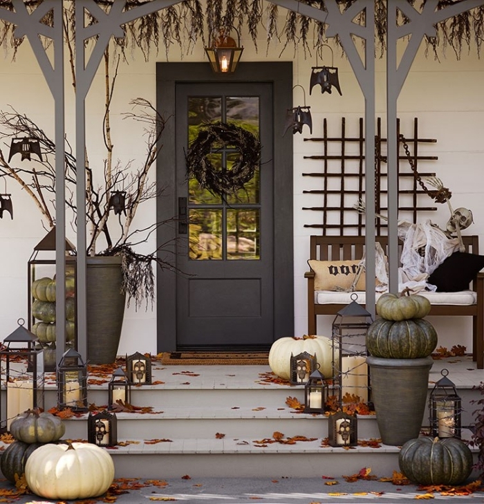 porte d'entrée et véranda de style halloween, citrouilles blanches et grises avec lanternes noires et bougies blanches