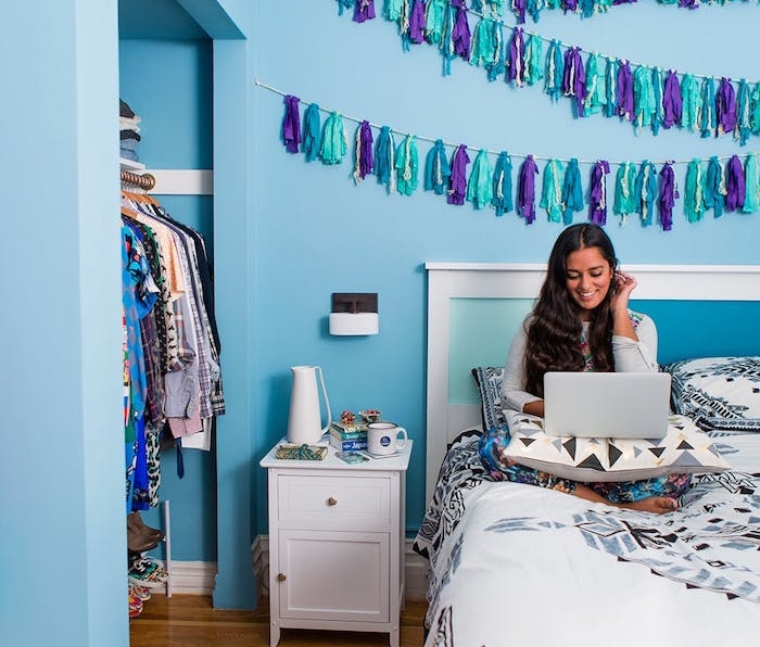 diy chambre ado, exemple de diy deco de pompons à franges bleu et violet sur un mur bleu, dressing pratique, linge de lit à motifs géométriques